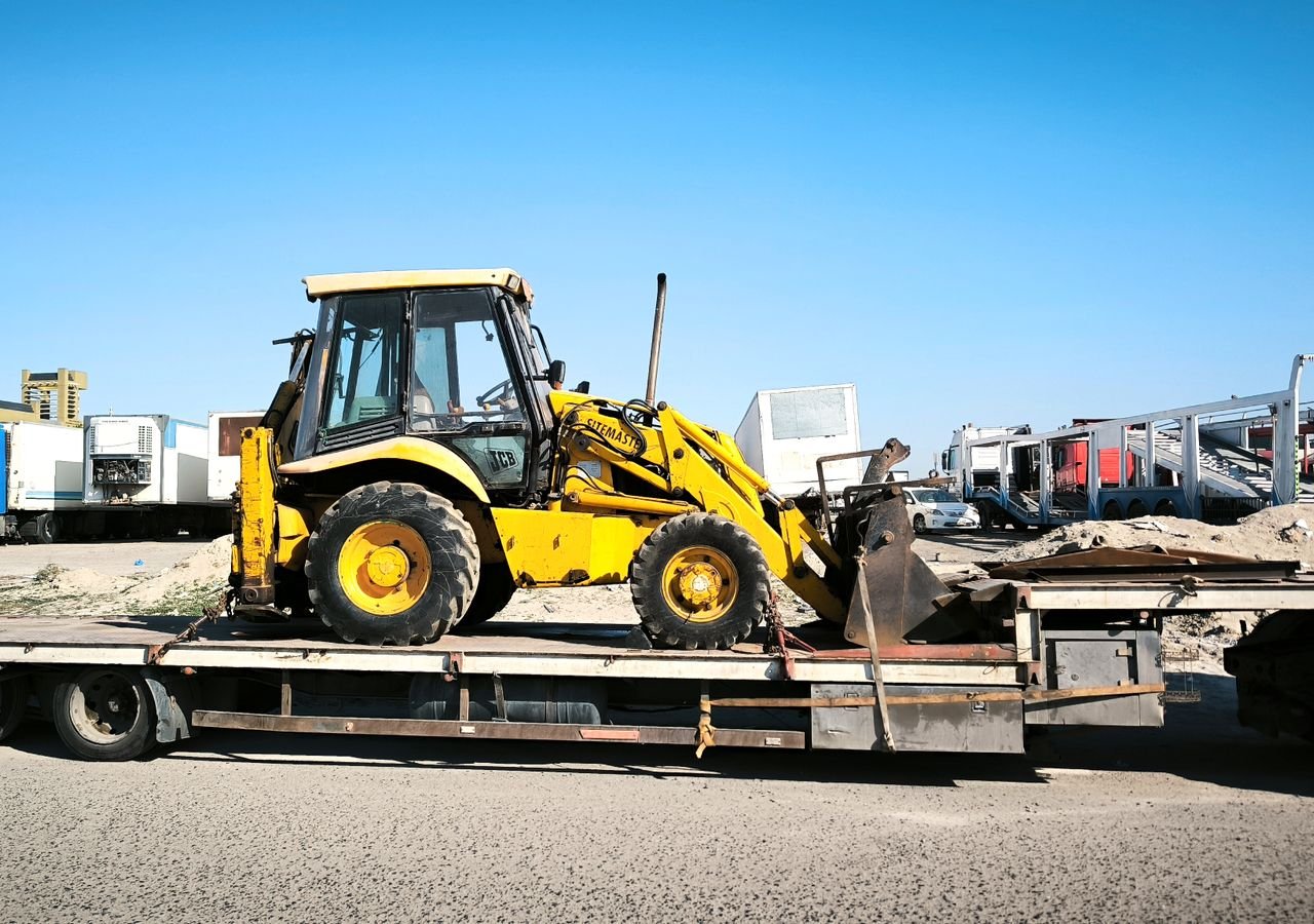 Heavy haul step-deck trailer carrying construction equipment